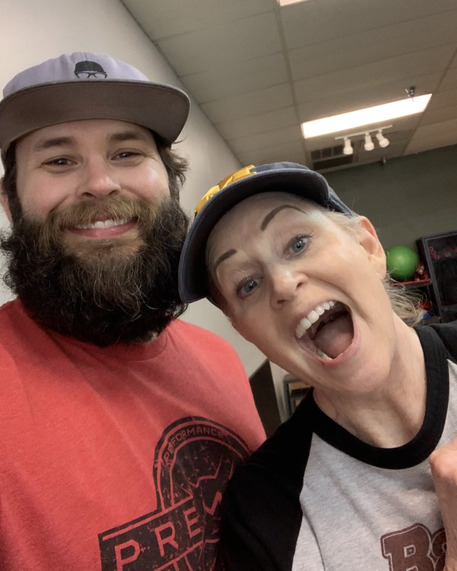A client laughing beside her grinning coach